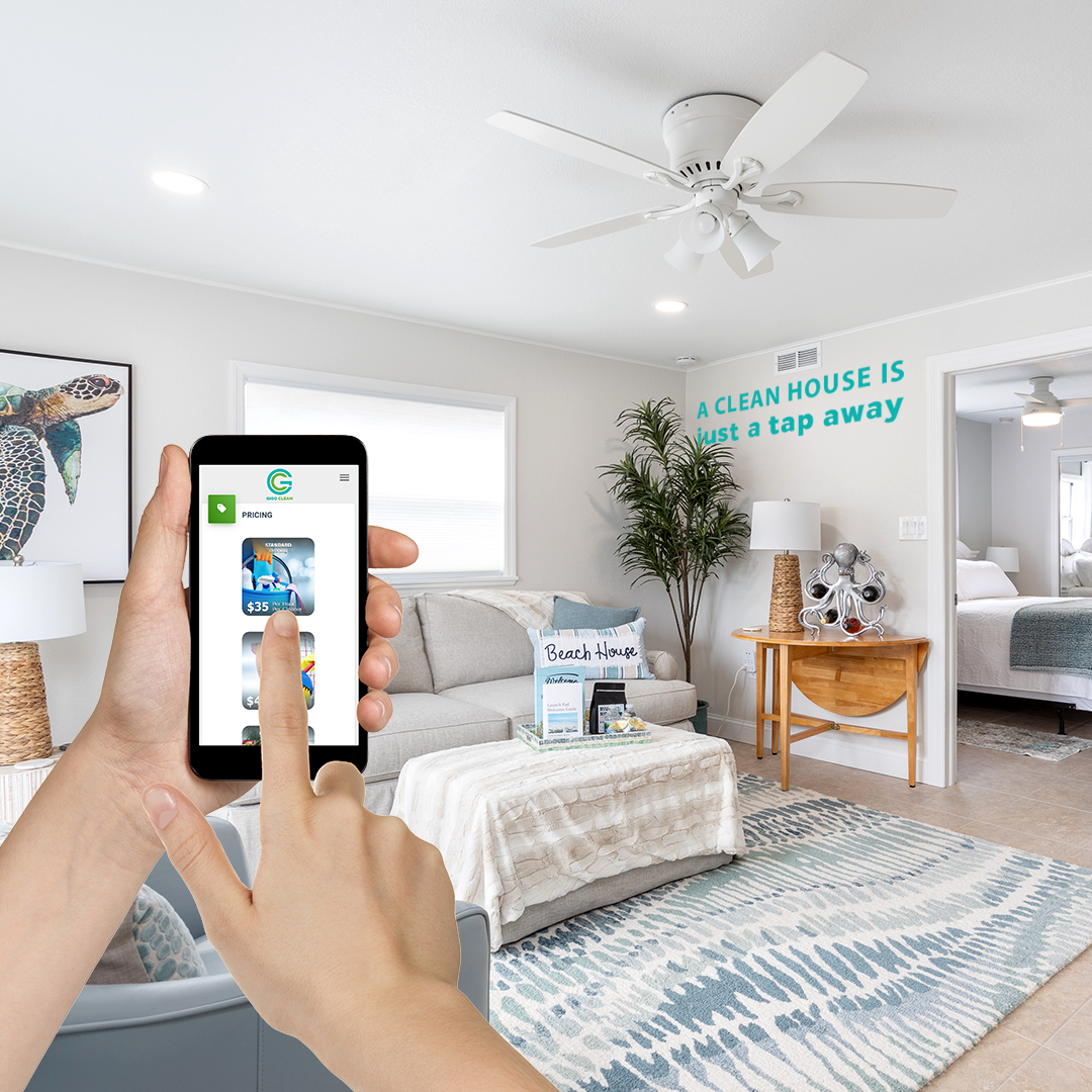 Person using GiGO Clean mobile app to book a professional home cleaning service, clean modern living room with text ‘A clean house is just a tap away